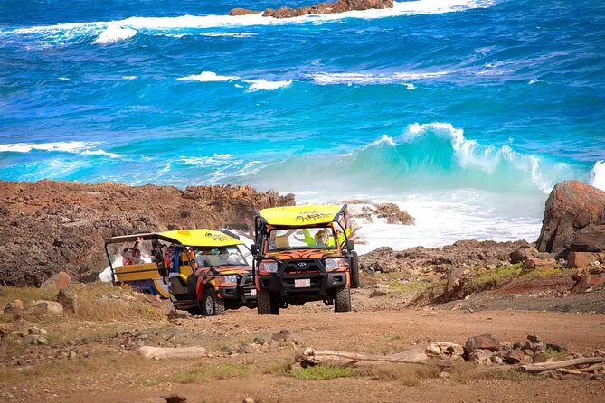Open 4x4 vehicles parked above the Natural Pool and the sea
